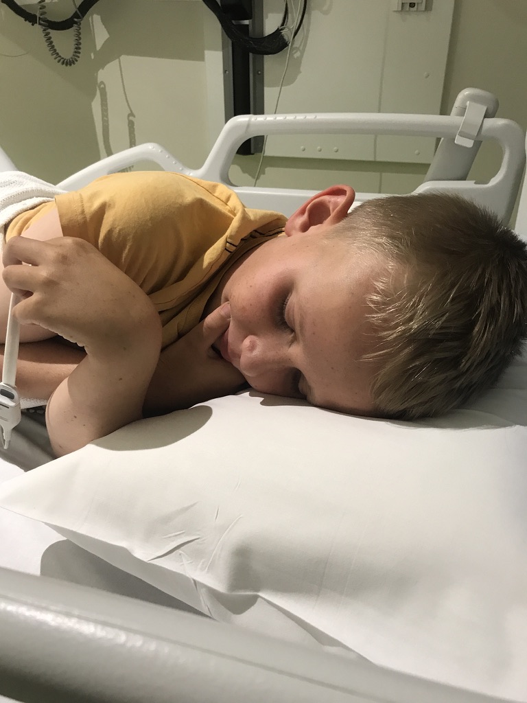 Byron asleep in a hospital bed